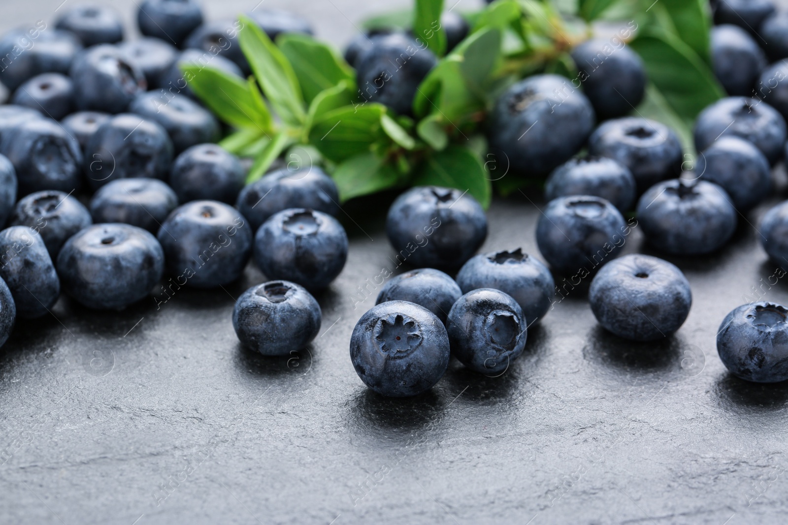 Photo of Tasty fresh blueberries on grey table, closeup