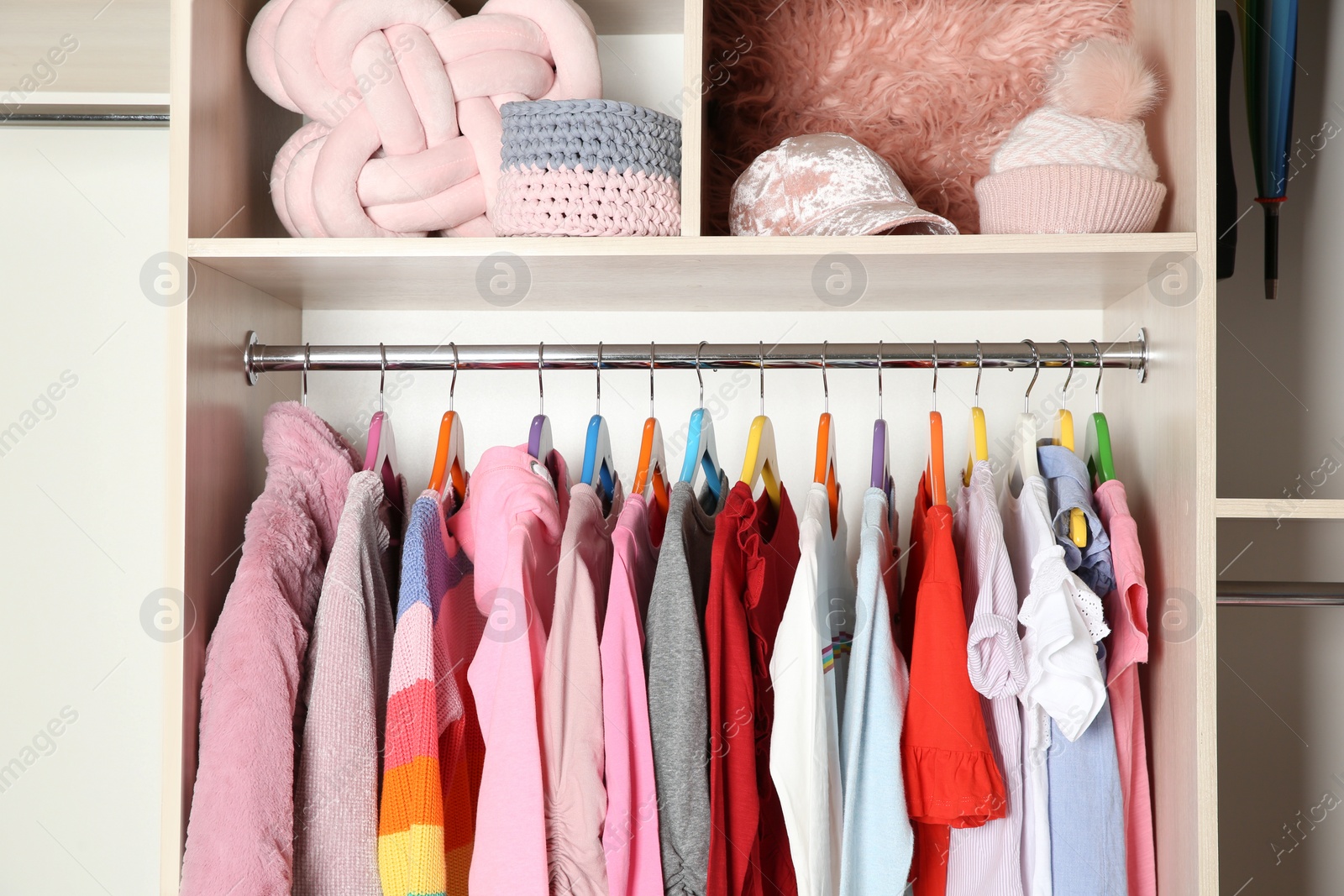 Photo of Wardrobe with stylish girl's clothes hanging on rack