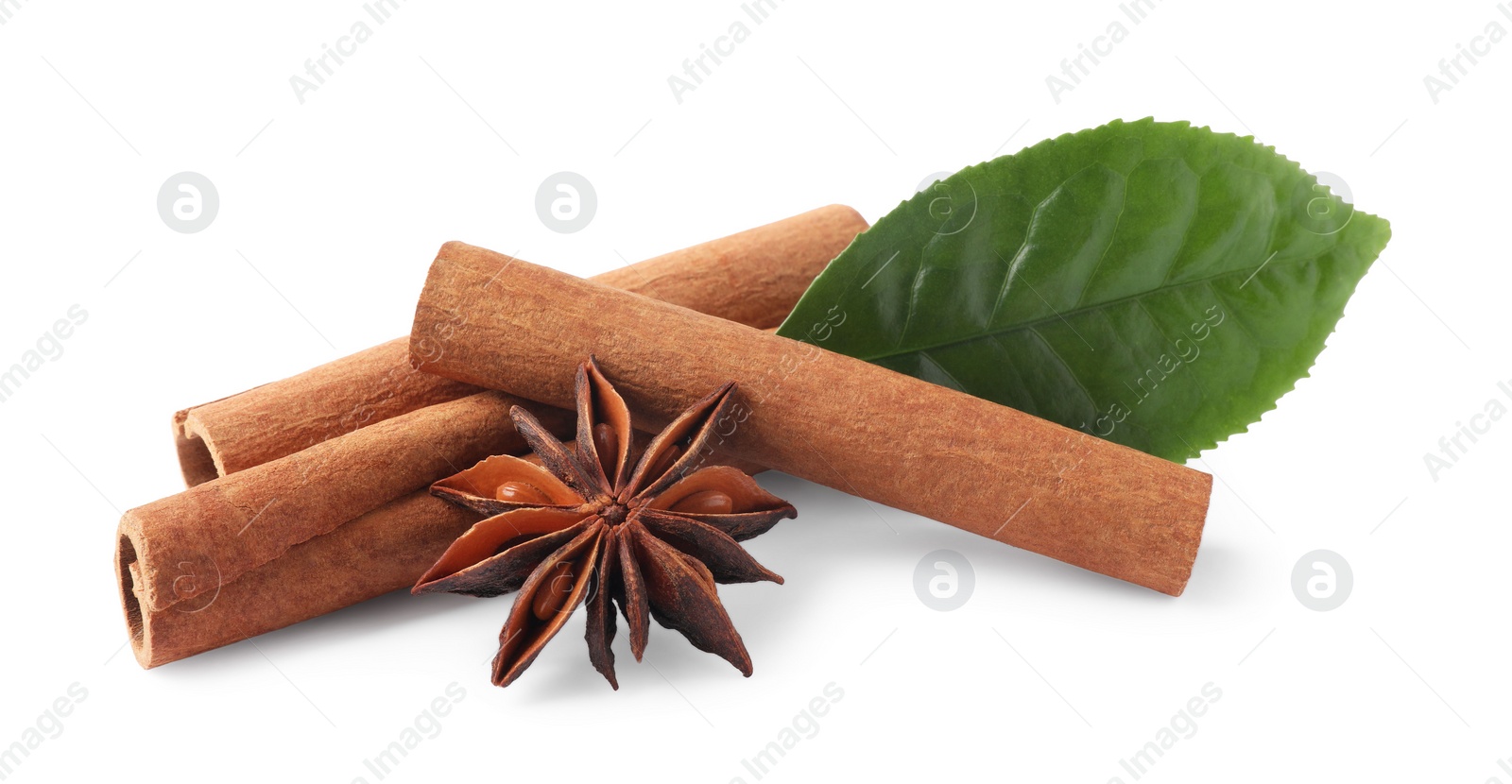 Photo of Aromatic cinnamon sticks, anise star and green leaf isolated on white