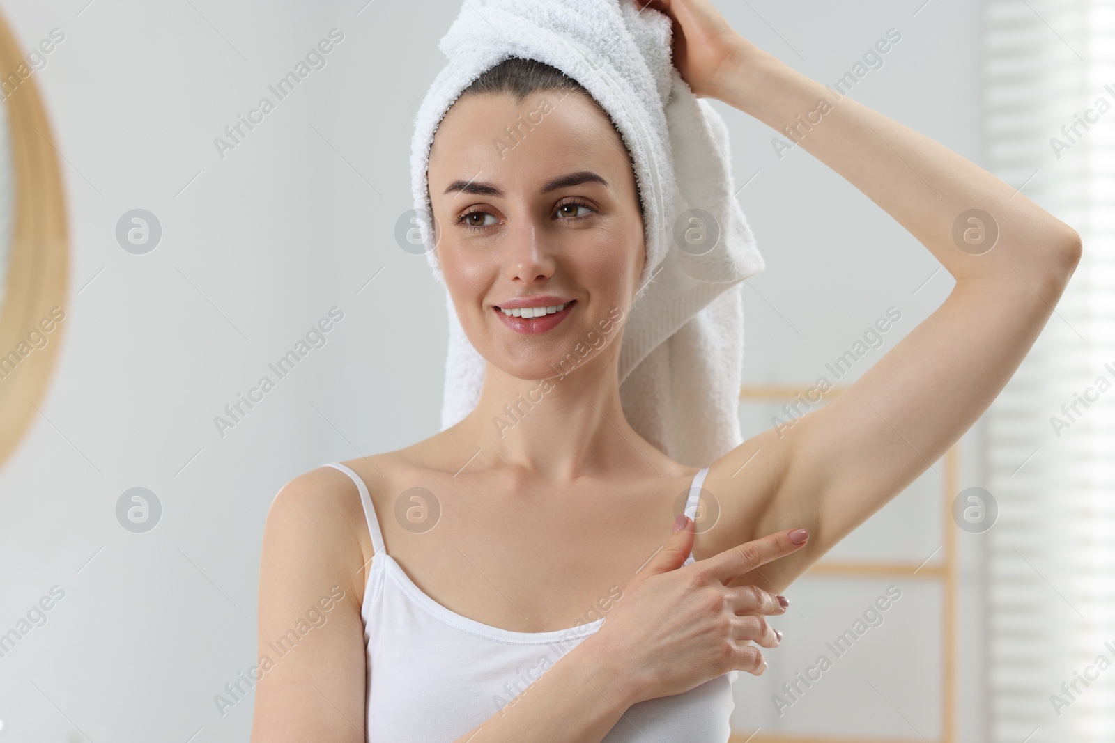 Photo of Beautiful woman showing armpit with smooth clean skin in bathroom