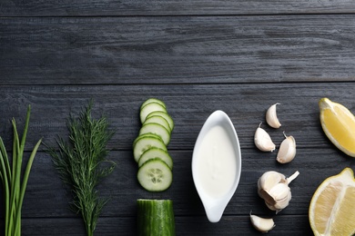 Photo of Flat lay composition with cucumber sauce and ingredients on wooden background. Space for text