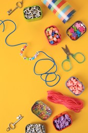 Photo of Handmade jewelry kit for kids. Colorful beads, bracelet and different supplies on orange background, flat lay