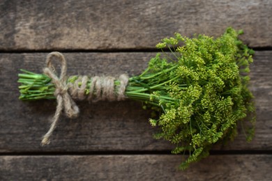 Photo of Bunch of beautiful blossom dill on wooden table, top view