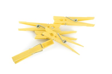 Photo of Bright yellow plastic clothespins on white background