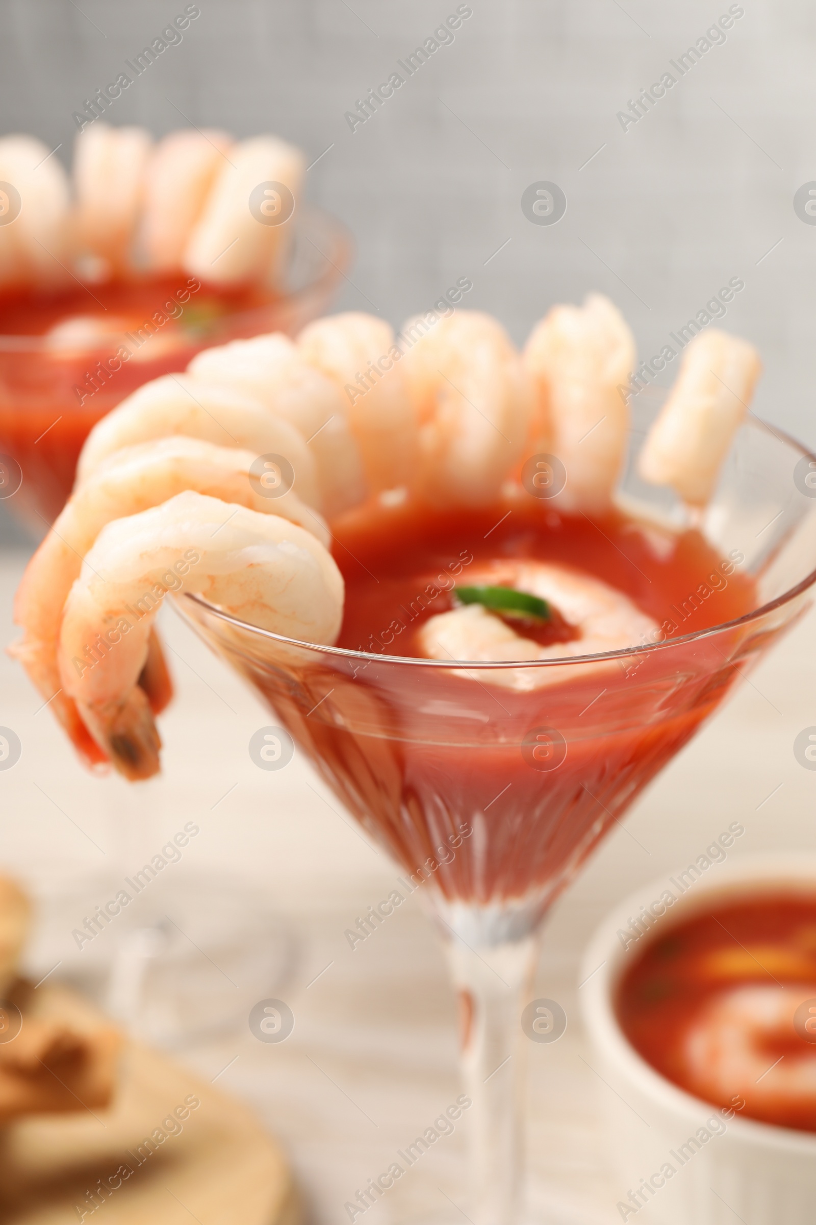 Photo of Tasty shrimp cocktail with sauce in glasses on table, closeup