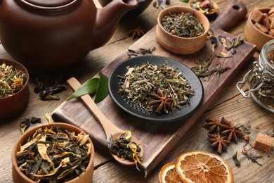 Photo of Different dry aromatic teas on wooden table