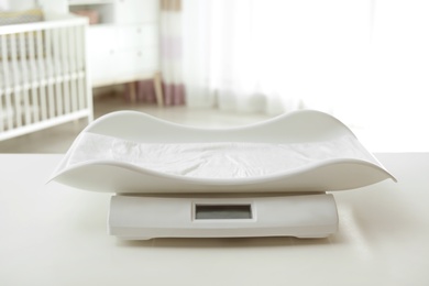 Photo of Modern baby scales on table in light room