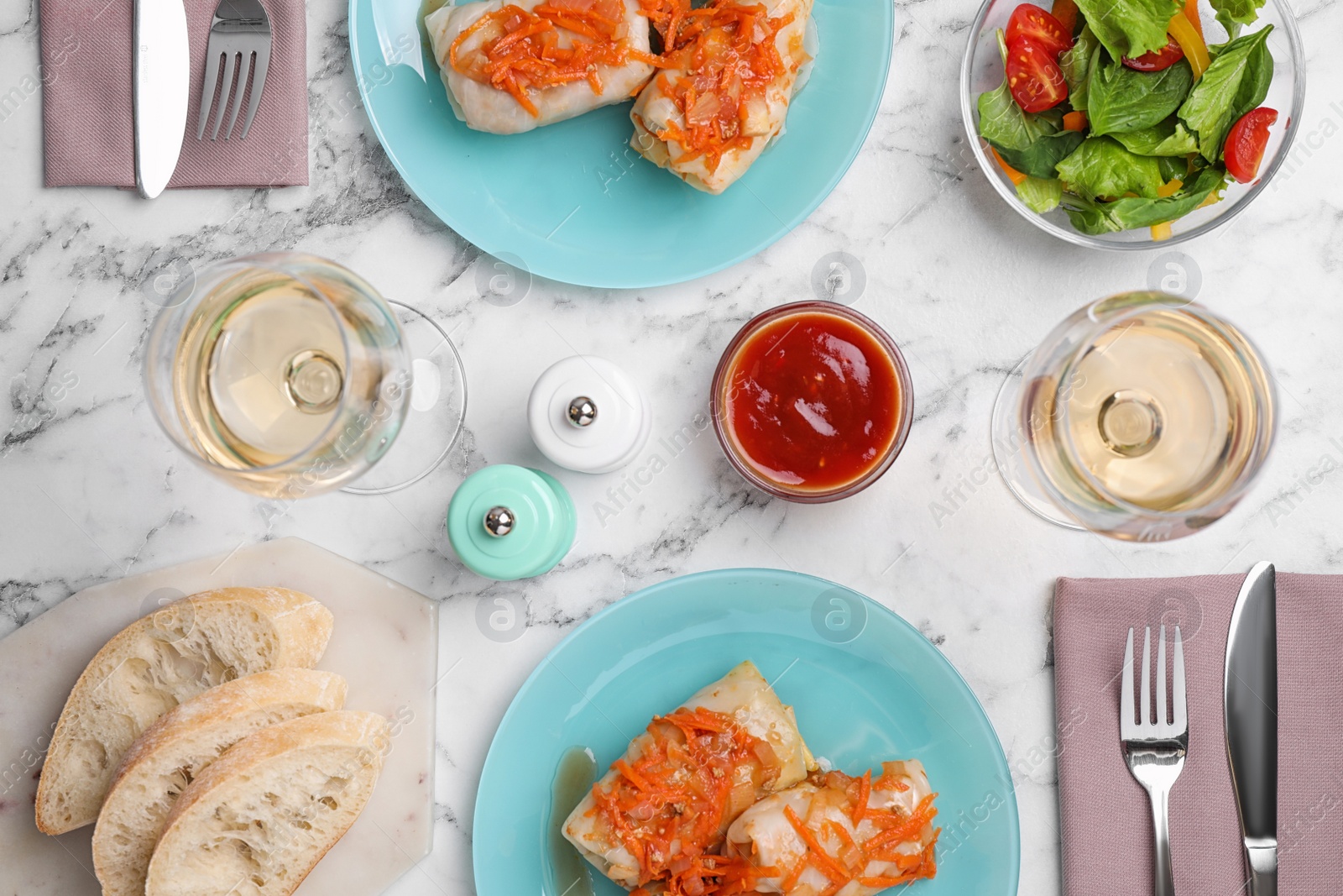 Photo of Delicious cabbage rolls served on white marble table, flat lay