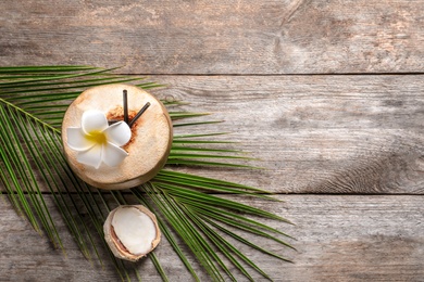 Photo of Beautiful composition with fresh green coconut and palm leaf on wooden background