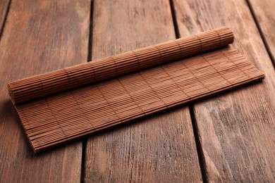 Photo of New rolled bamboo mat on wooden table