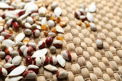 Mixed vegetable seeds on wicker background, closeup