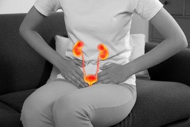 Woman suffering from cystitis on sofa at home, closeup. Illustration of urinary system