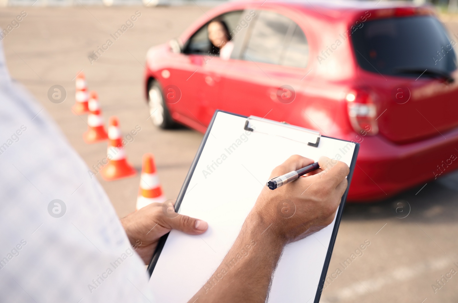 Photo of Instructor with clipboard near car outdoors, closeup. Driving school exam