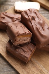 Photo of Tasty chocolate bars with nougat on wooden table, closeup
