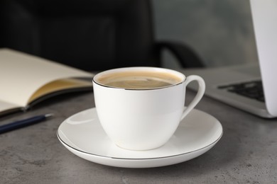 Photo of Cup of americano on grey table in office. Coffee Break