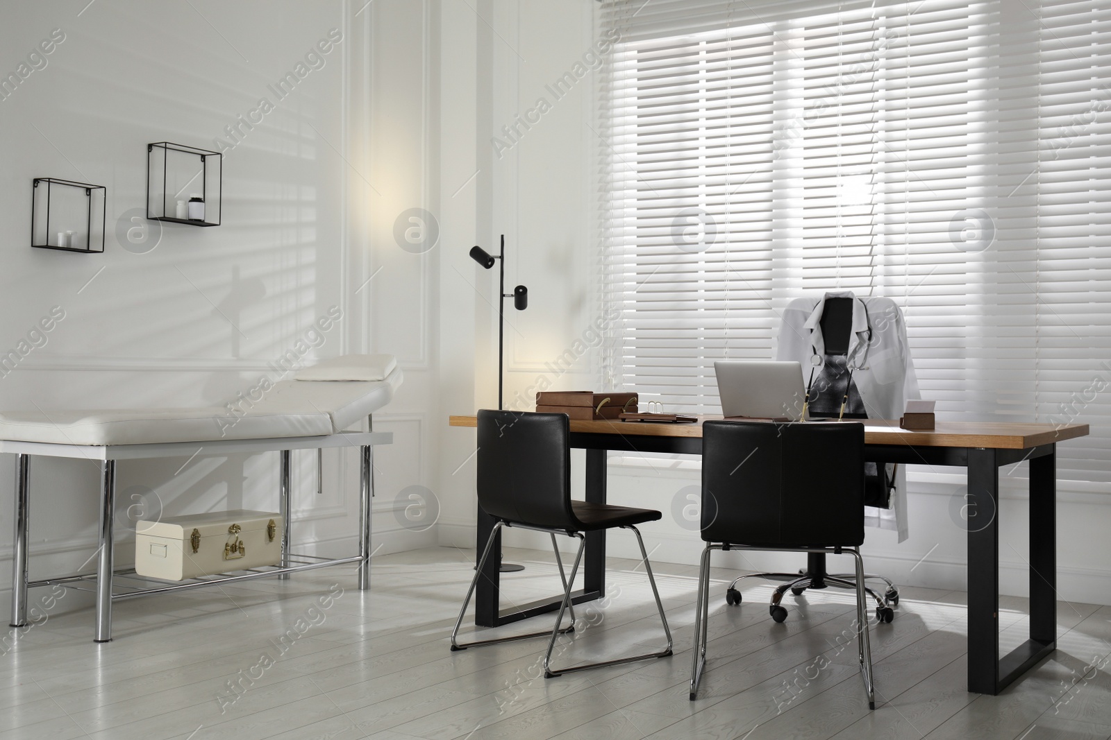 Photo of Modern medical office interior with doctor's workplace and examination table