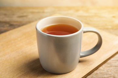 Cup of black tea on wooden board