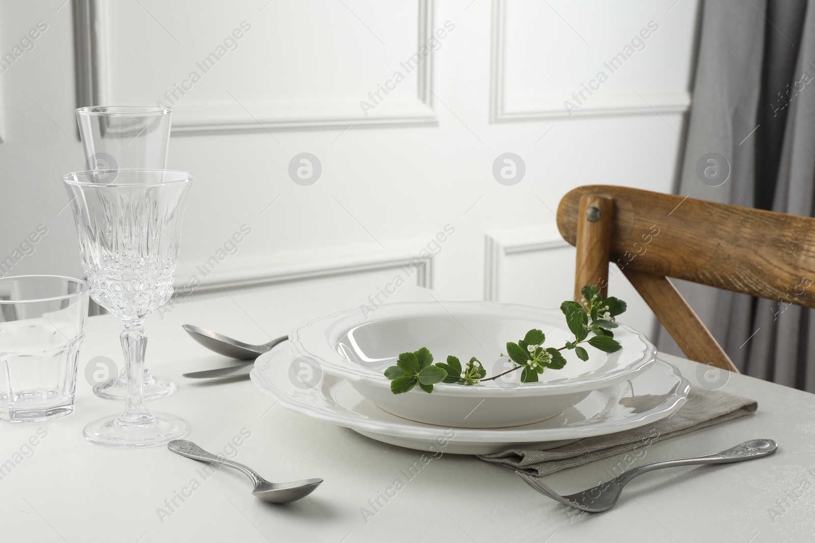 Photo of Stylish setting with cutlery and plates on white textured table