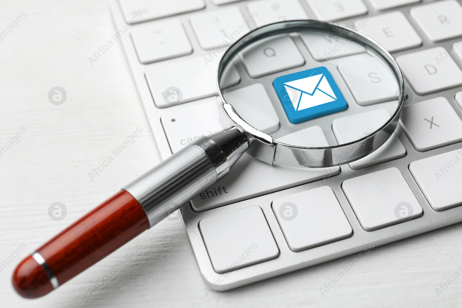 Image of Email. Light blue button with illustration of envelope on computer keyboard, view through magnifying glass, closeup