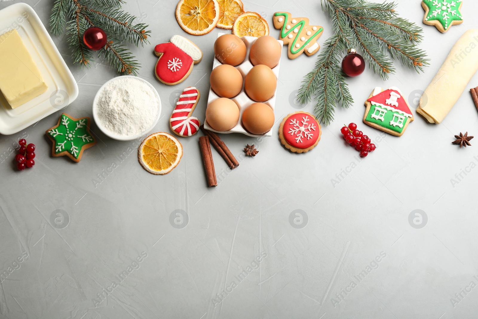 Photo of Flat lay composition with homemade Christmas cookies and ingredients on grey table, space for text