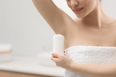 Photo of Woman applying deodorant in bathroom, closeup. Space for text