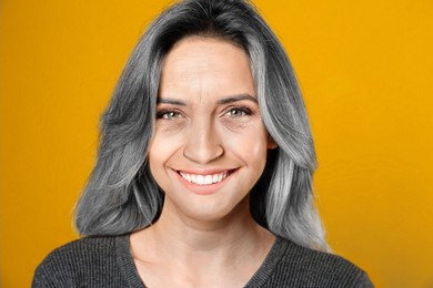Image of Portrait of senior woman on orange background