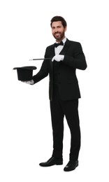 Photo of Happy magician showing magic trick with top hat on white background