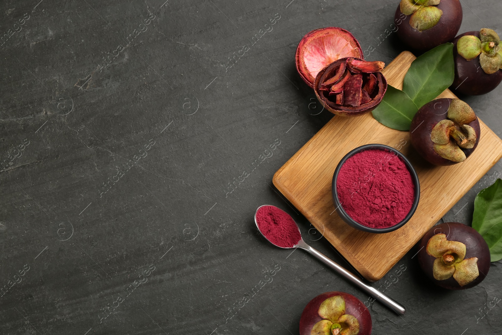 Photo of Purple mangosteen powder and fruits on black table, flat lay. Space for text
