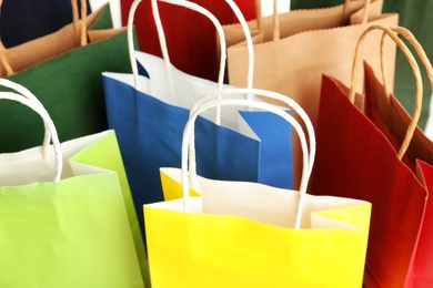 Photo of Colorful paper shopping bags as background, closeup