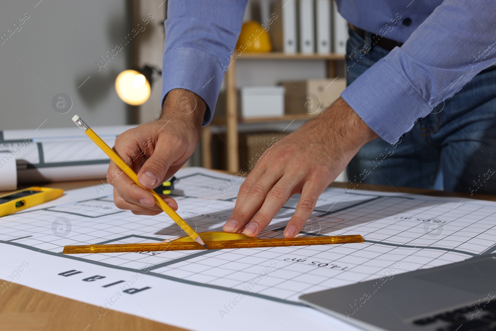 Photo of Architect working with construction drawings in office, closeup