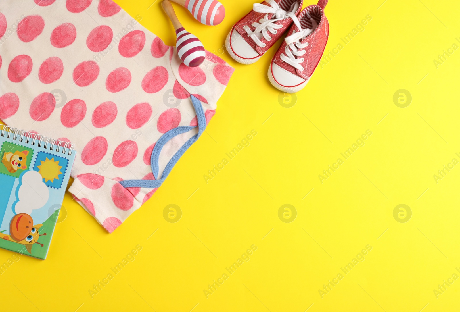 Photo of Flat lay composition with bodysuit and space for text on color background. Baby accessories