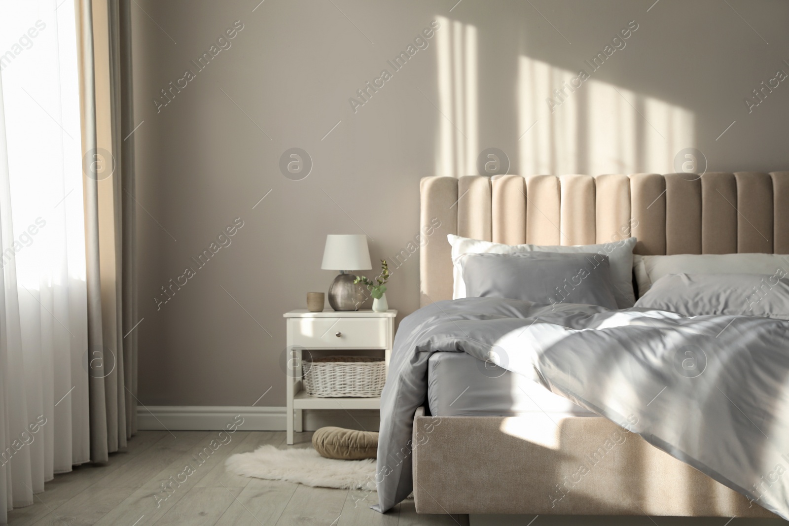 Photo of Bed with stylish silky linens in room
