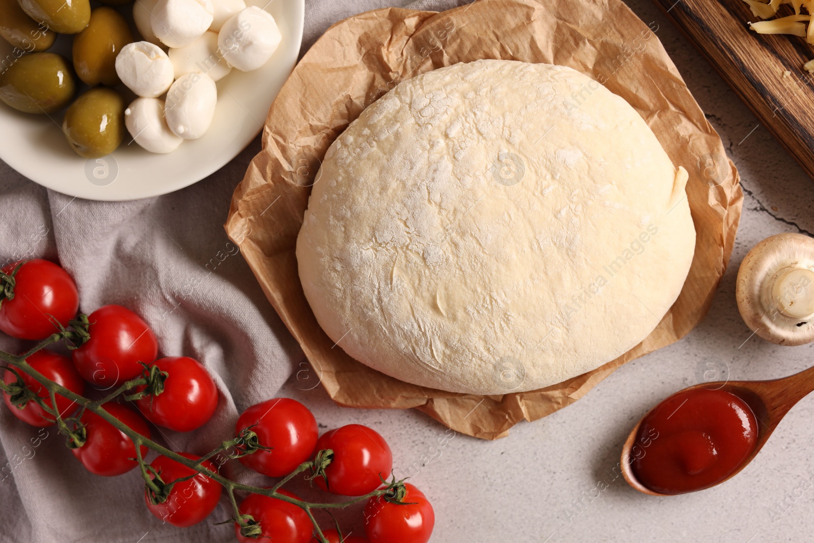 Photo of Pizza dough and products on gray textured table, flat lay