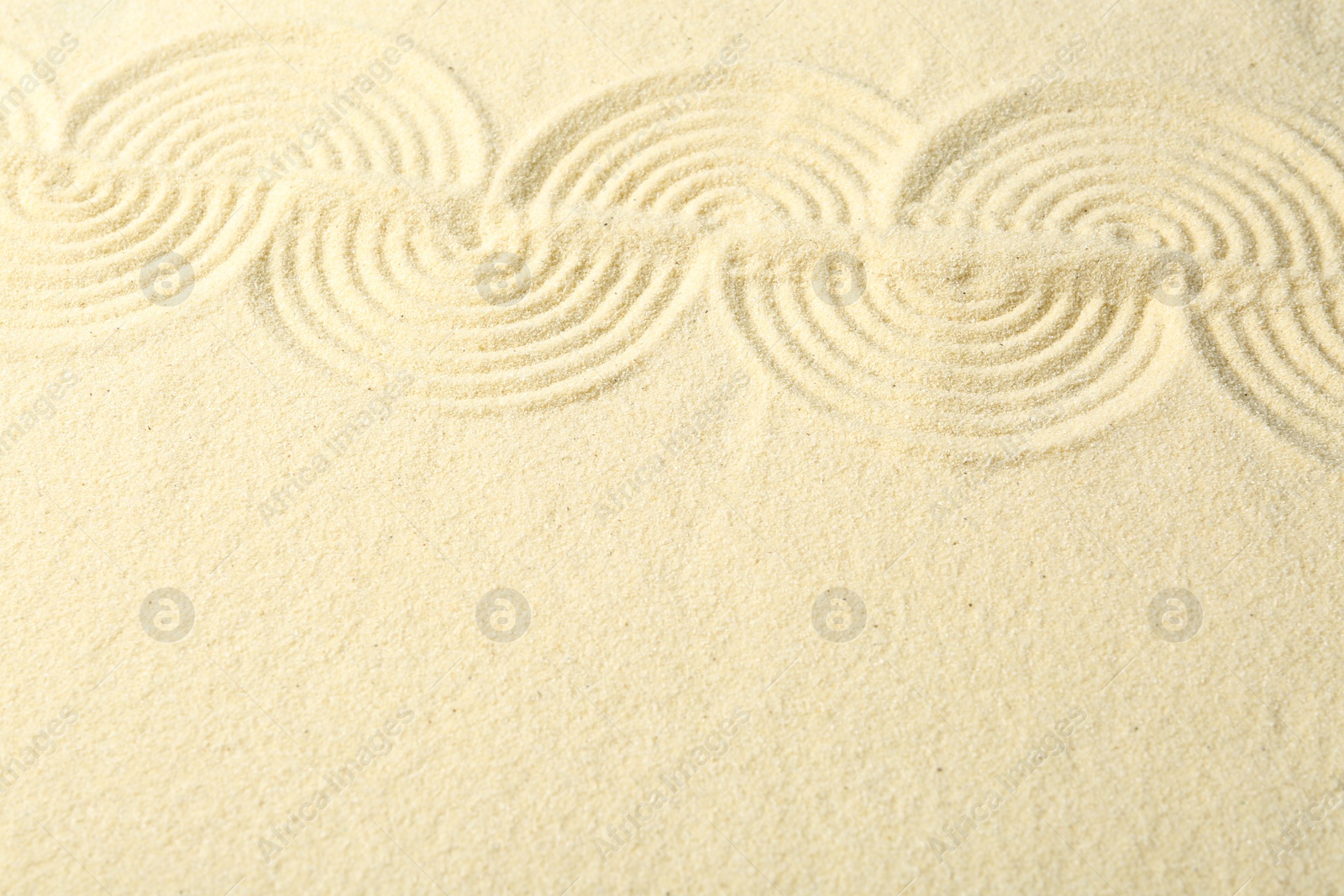 Photo of Zen rock garden. Wave pattern on beige sand