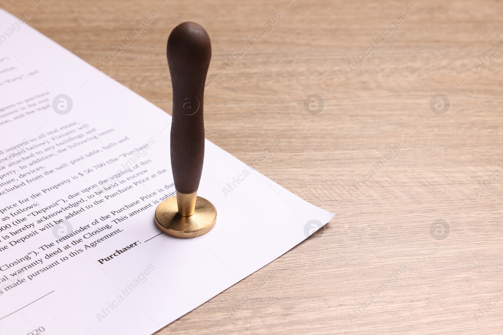 Photo of One stamp tool and document on wooden table. Space for text