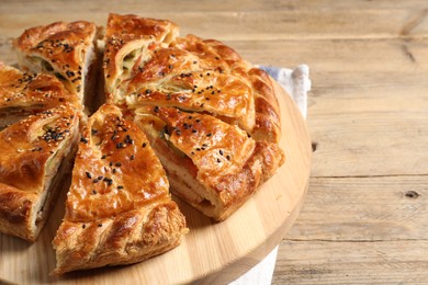 Cut delicious homemade pie on wooden table, closeup. Space for text