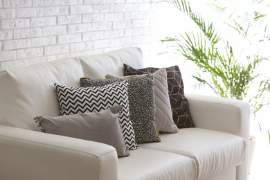 Comfortable sofa with different soft pillows indoors