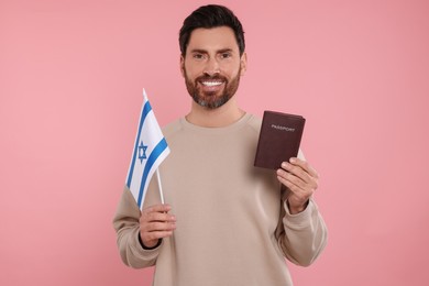 Immigration. Happy man with passport and flag of Israel on pink background