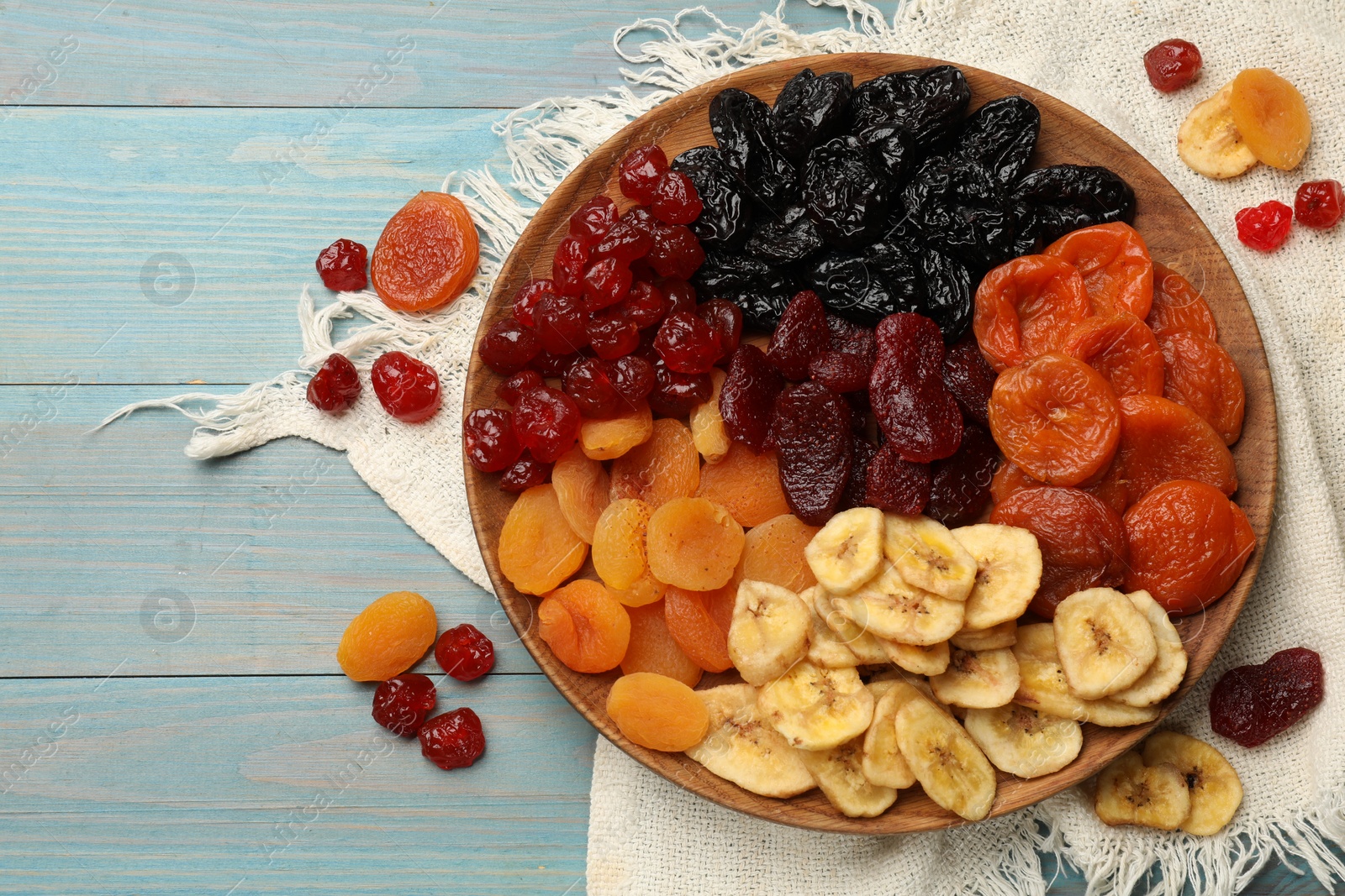 Photo of Delicious dried fruits on light blue wooden table, flat lay