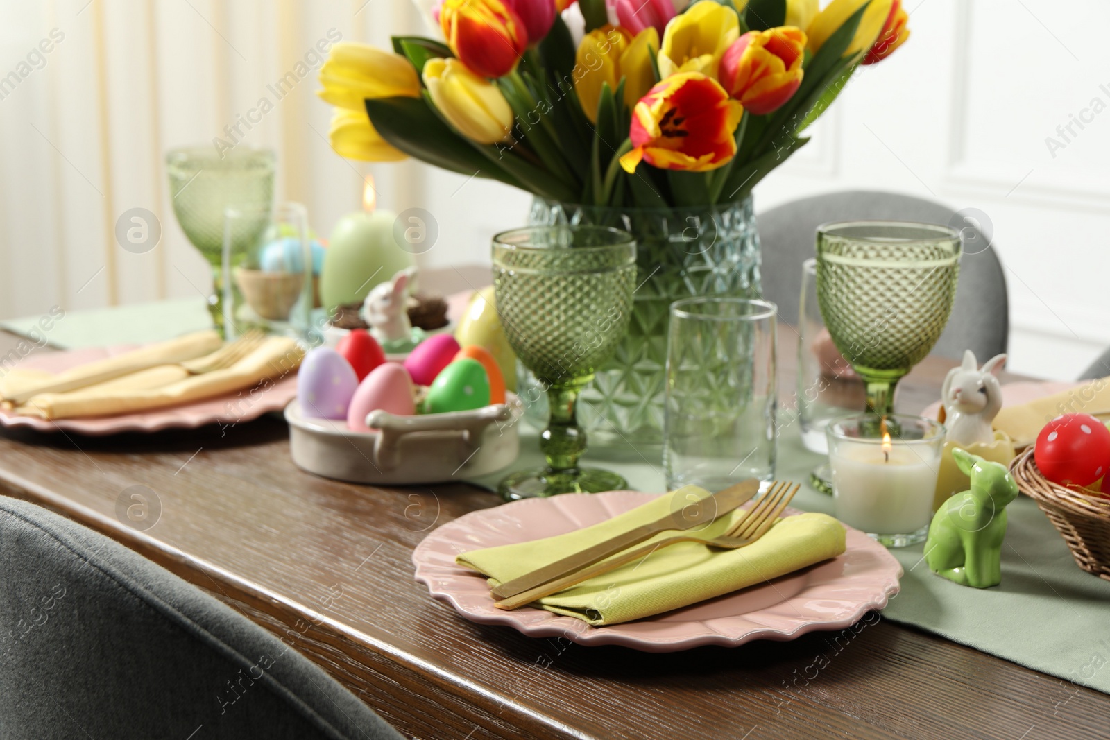 Photo of Easter celebration. Festive table setting with beautiful flowers and painted eggs