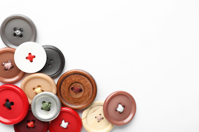 Many colorful sewing buttons on white background, top view