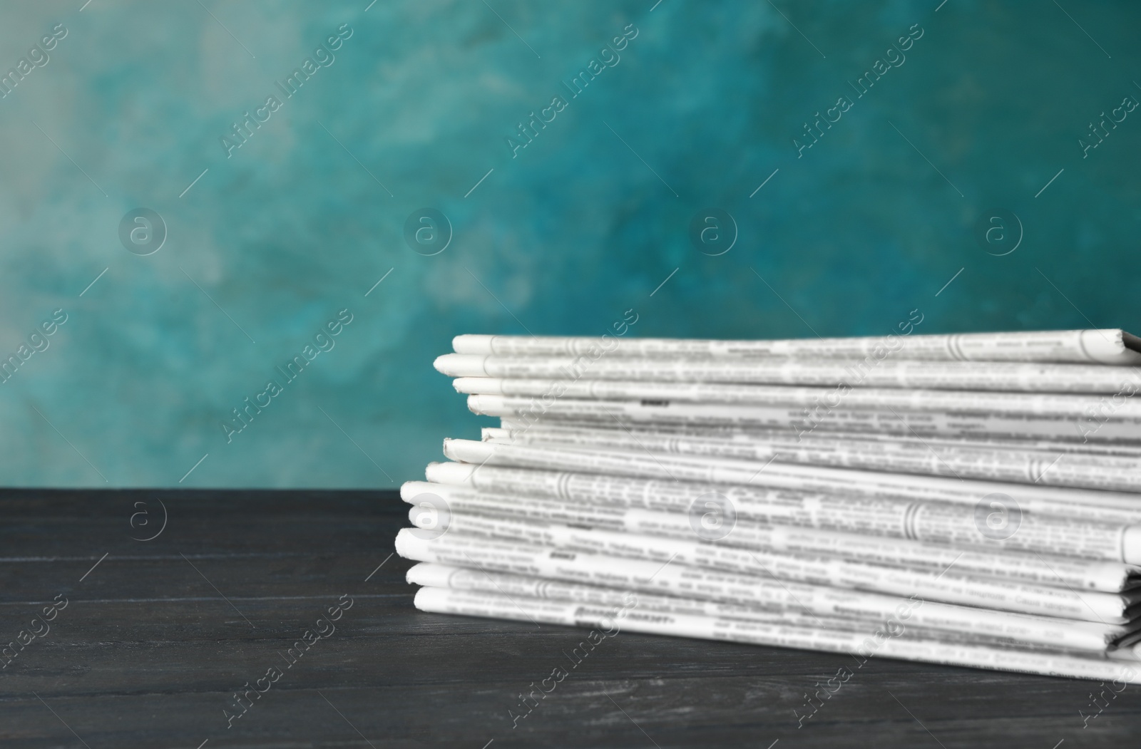 Photo of Stack of newspapers on wooden table. Journalist's work