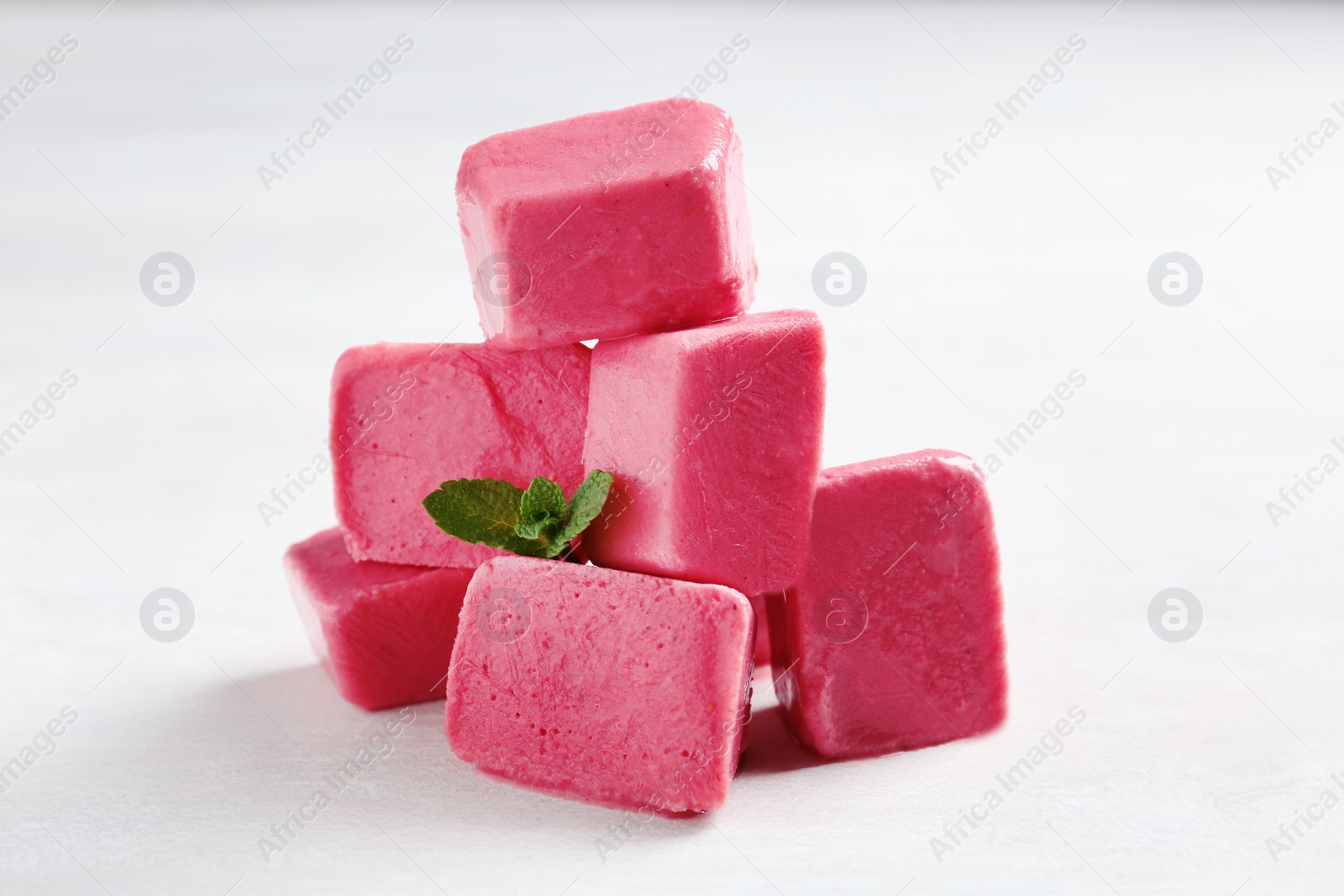 Photo of Tasty berry ice cubes on light table