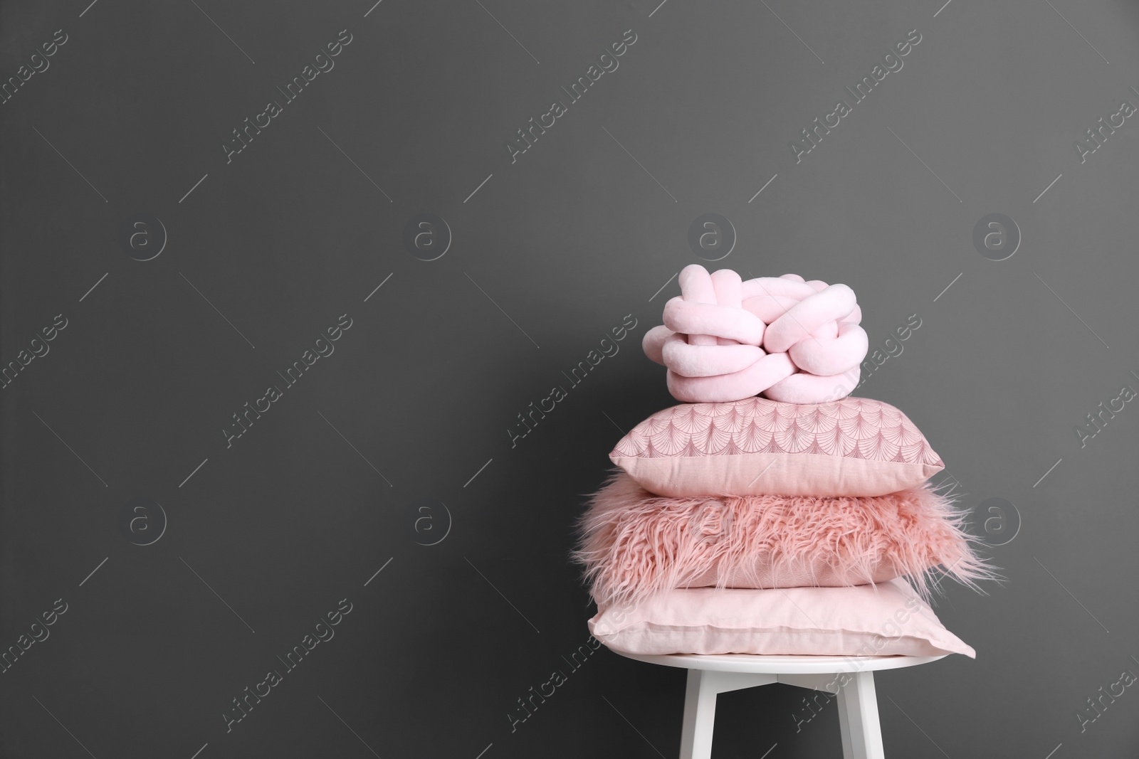 Photo of Chair with many different pillows and space for text on color background