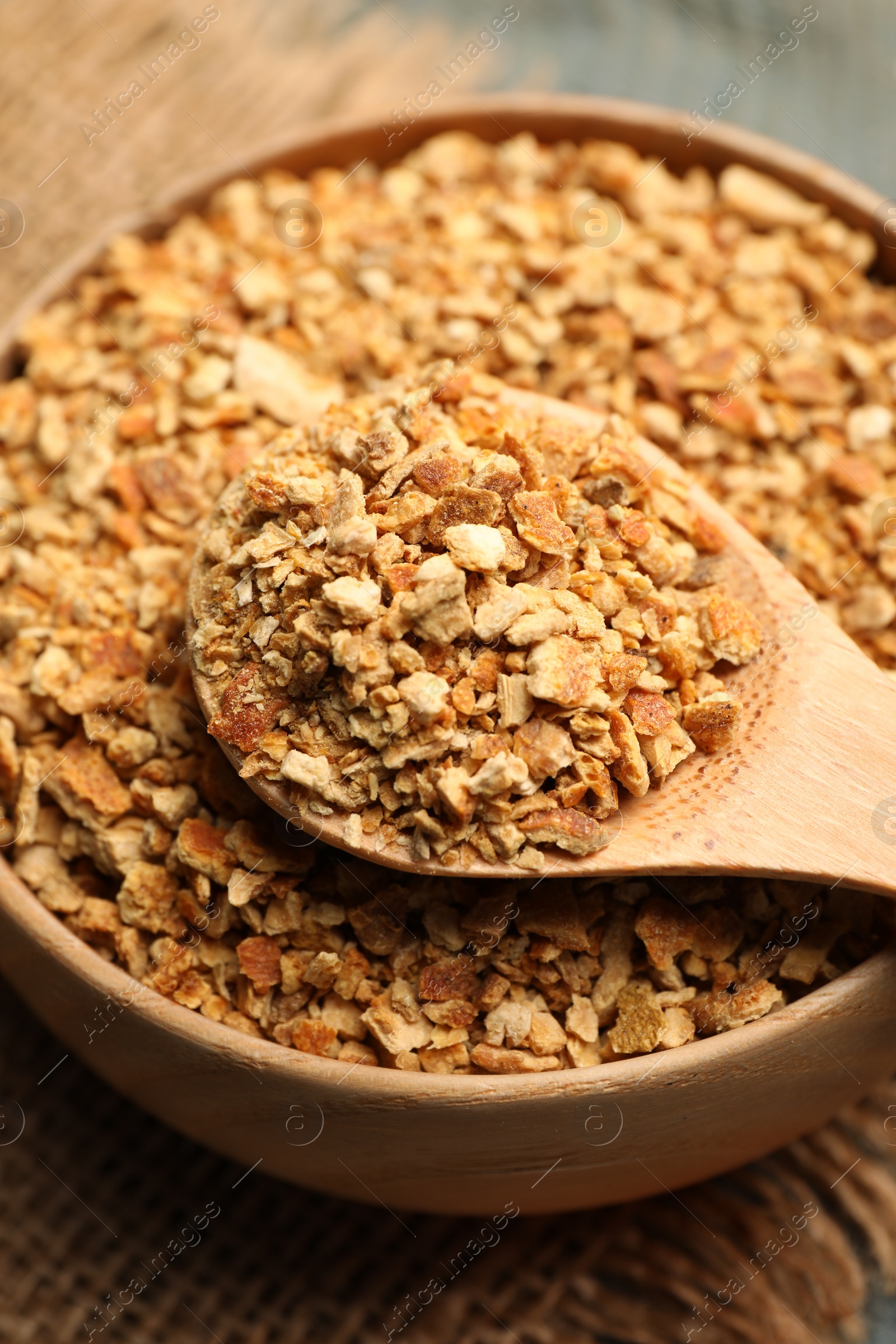 Photo of Bowl and spoon with dried orange zest seasoning on table, closeup