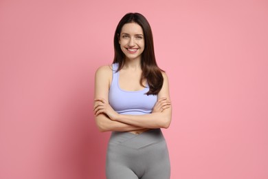 Happy young woman with slim body on pink background