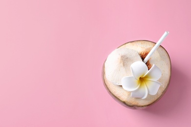 Photo of Fresh green coconut with drinking straw and flower on color background, top view