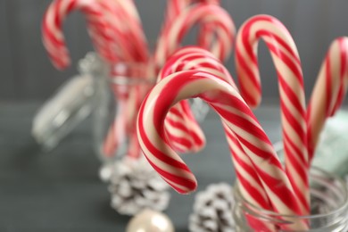 Many sweet candy canes in glass on table, closeup. Traditional Christmas treat