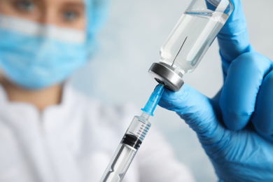 Photo of Doctor filling syringe with medication, closeup. Vaccination and immunization