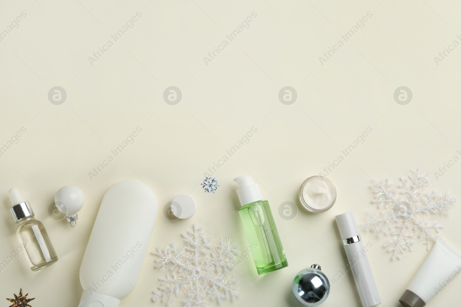 Photo of Flat lay composition with different cosmetic products on beige background, space for text. Winter care